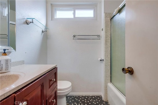 full bathroom with shower / bath combination with glass door, tile patterned flooring, vanity, and toilet