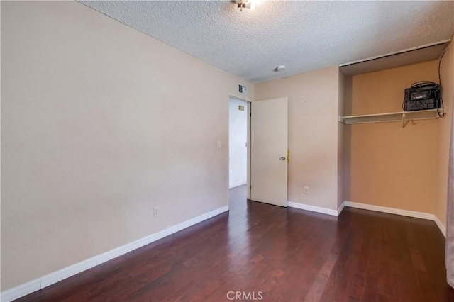 unfurnished bedroom with dark hardwood / wood-style flooring, a closet, and a textured ceiling