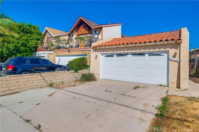 14728 Mansel Ave, Lawndale, CA 90260 - view of front facade with a balcony, concrete driveway, stucco siding, and a tile roof