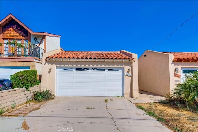 14728 Mansel Ave, Lawndale, CA 90260 - view of front of property featuring a garage, stucco siding, a tiled roof, a balcony, and concrete driveway