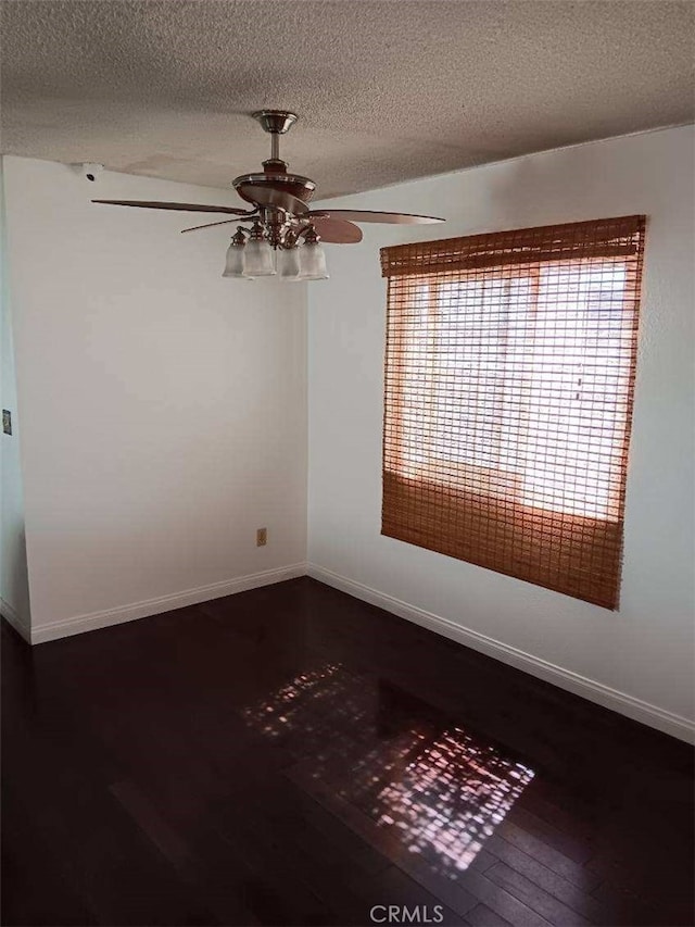 unfurnished room with a textured ceiling, dark hardwood / wood-style floors, and ceiling fan