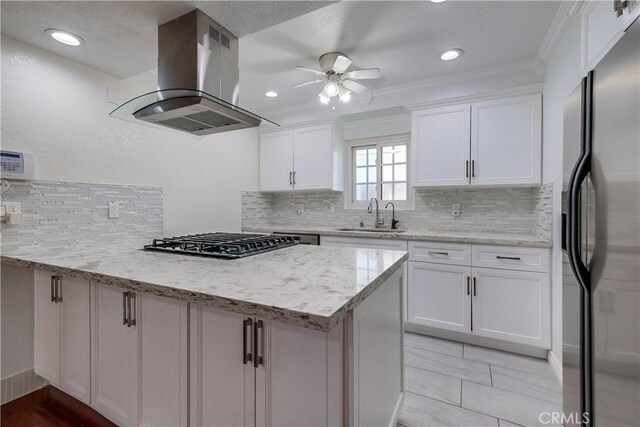 kitchen with white cabinets, ceiling fan, light stone countertops, island range hood, and stainless steel appliances