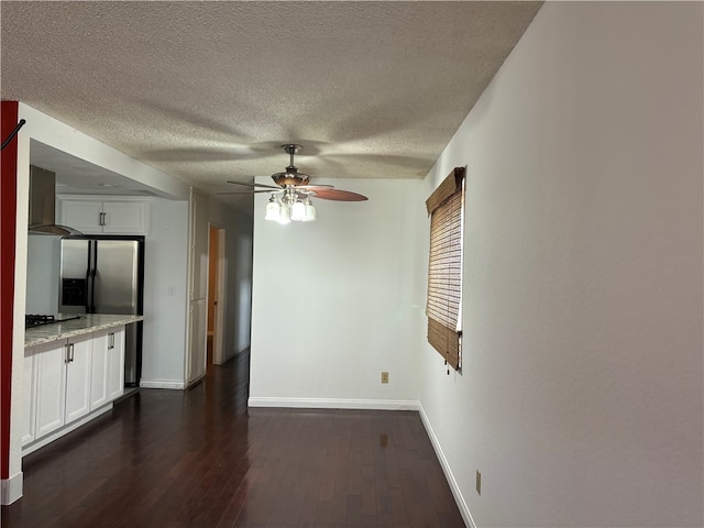 unfurnished living room with ceiling fan, dark hardwood / wood-style flooring, and a textured ceiling