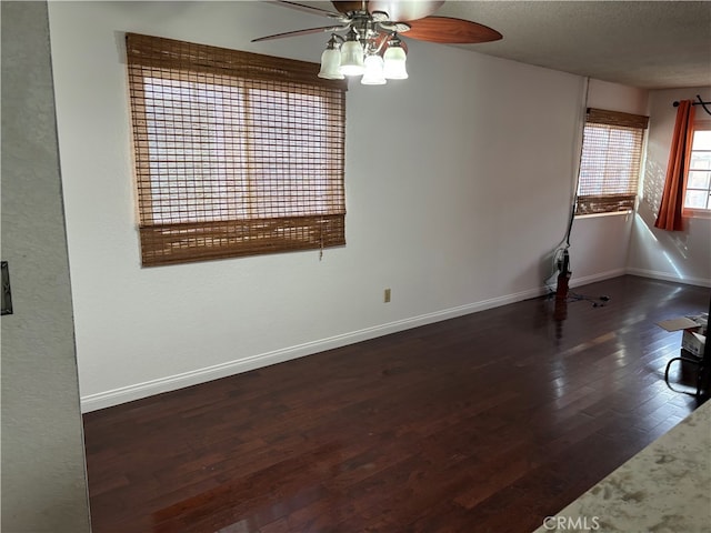 unfurnished room featuring ceiling fan, dark wood-type flooring, and a textured ceiling