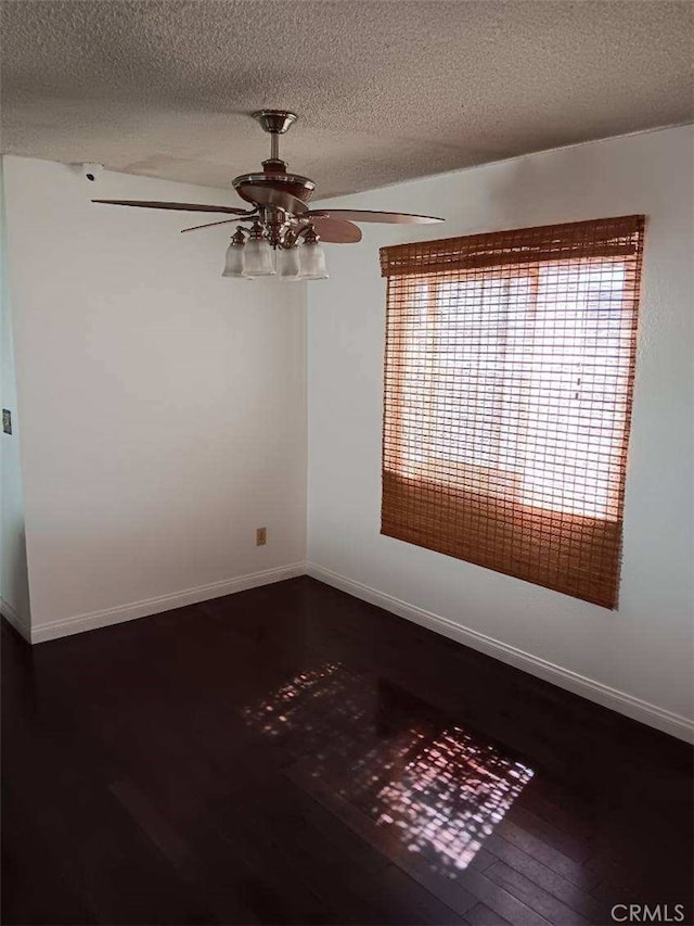 unfurnished room with a textured ceiling, ceiling fan, and dark wood-type flooring