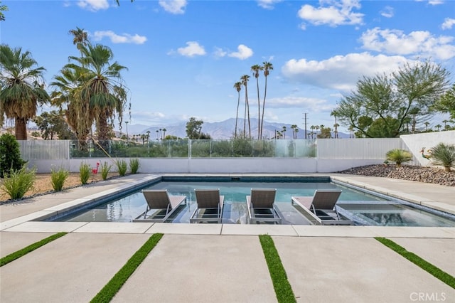 view of pool with a mountain view, an in ground hot tub, and a patio area