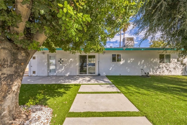 rear view of property with a lawn and a patio area