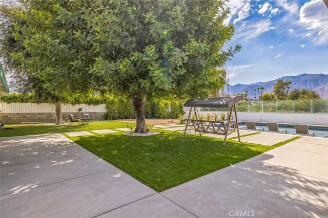 view of property's community featuring a patio, a mountain view, a yard, and a pool