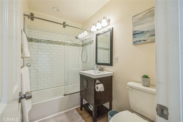 full bathroom with tiled shower / bath, vanity, and toilet