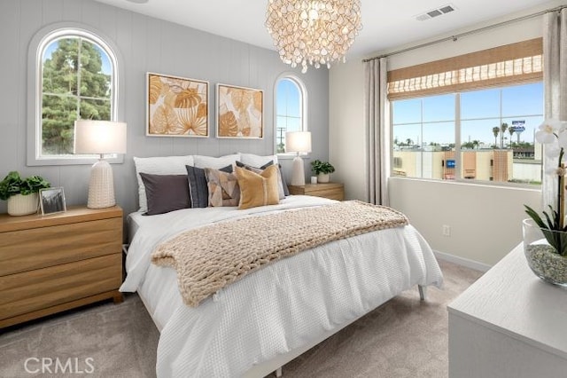 carpeted bedroom with an inviting chandelier