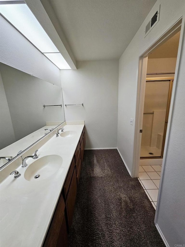 bathroom featuring tile patterned floors, vanity, and a shower