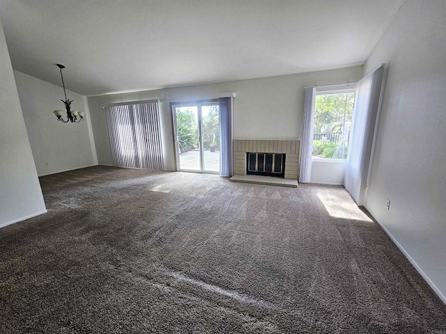 unfurnished living room featuring carpet, a fireplace, and a chandelier