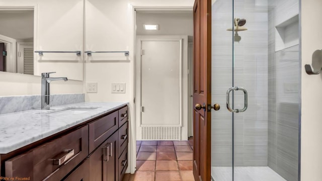 bathroom featuring a shower with door and vanity