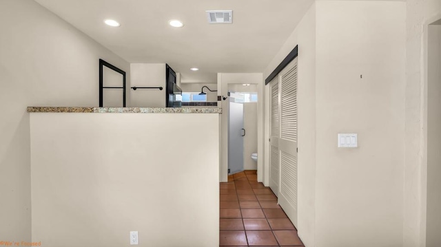 hall with dark tile patterned flooring