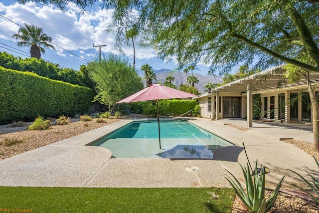 view of swimming pool with a mountain view, a patio area, and french doors