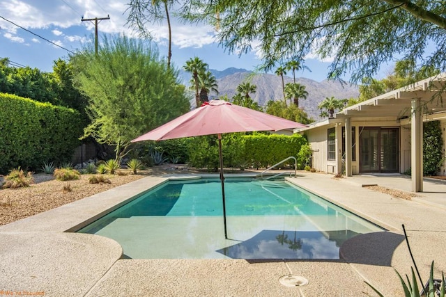 view of swimming pool with a mountain view and a patio