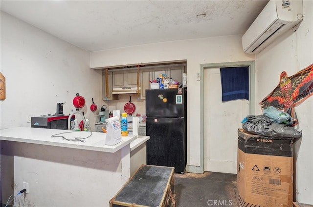 kitchen with black fridge, a wall mounted air conditioner, sink, kitchen peninsula, and a kitchen bar