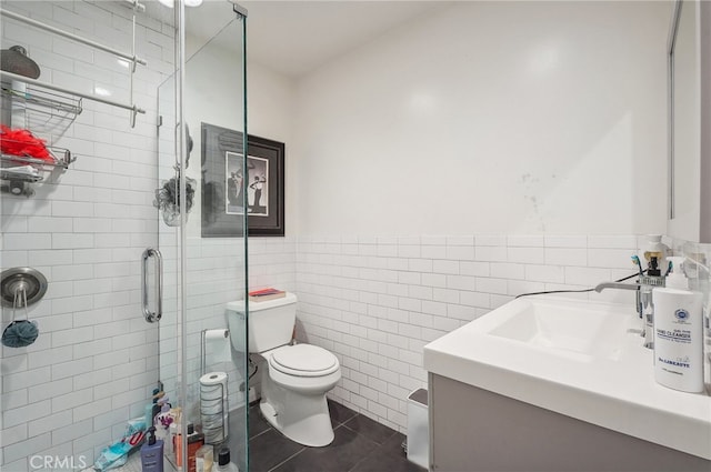 bathroom featuring walk in shower, vanity, tile walls, and toilet