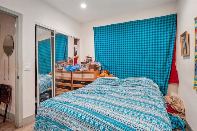 bedroom featuring wood-type flooring and a closet