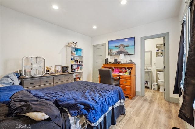 bedroom featuring light hardwood / wood-style floors and ensuite bathroom