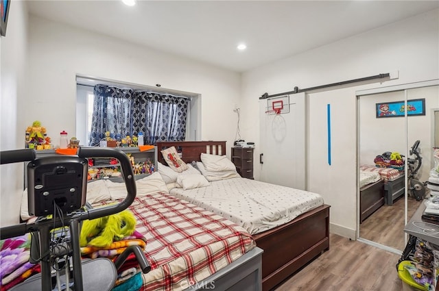 bedroom featuring light hardwood / wood-style flooring, a closet, and a barn door