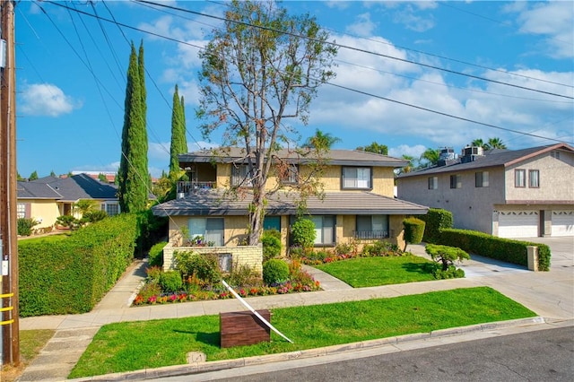 view of property featuring a front lawn and a garage