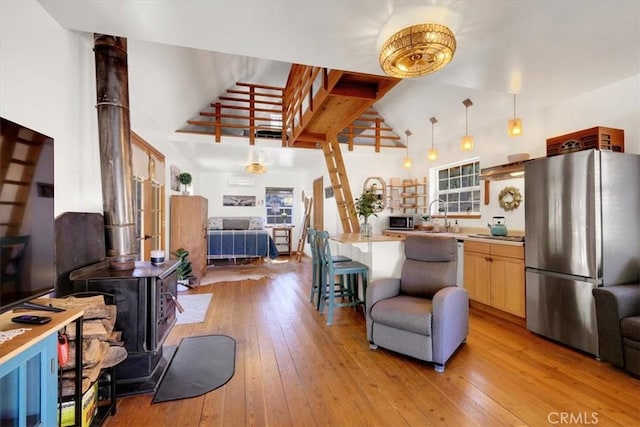 12828 Broyles Trl, Oregon House, CA 95962 - kitchen with stainless steel appliances, open floor plan, a wood stove, light wood-style flooring, and light countertops