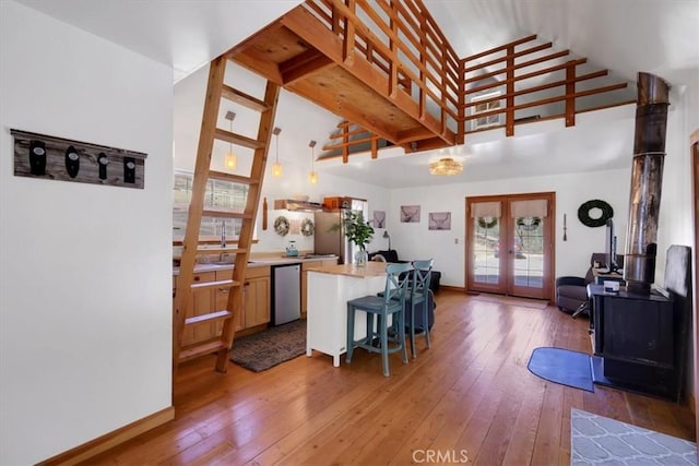 12828 Broyles Trl, Oregon House, CA 95962 - kitchen featuring french doors, high vaulted ceiling, stainless steel appliances, light wood finished floors, and a breakfast bar