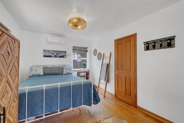 bedroom featuring wood-type flooring and a wall unit AC