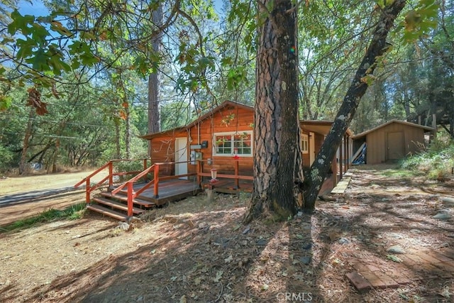 exterior space with a deck and a storage shed