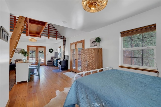 bedroom featuring wood-type flooring, french doors, and vaulted ceiling