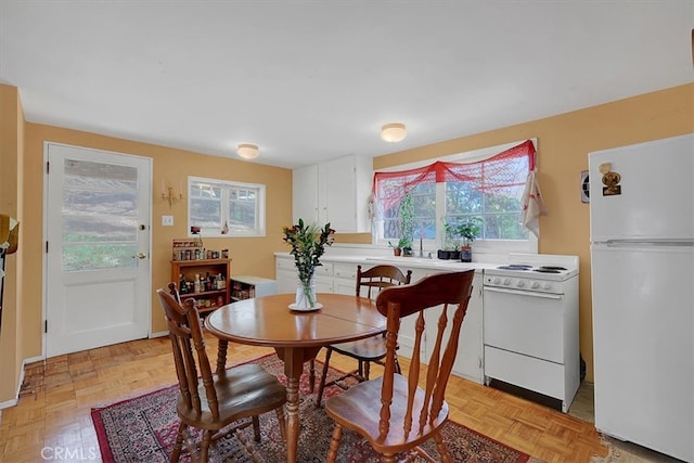 dining space featuring a healthy amount of sunlight and light parquet flooring