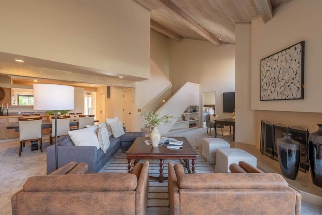 living room with light carpet, beam ceiling, and a high ceiling