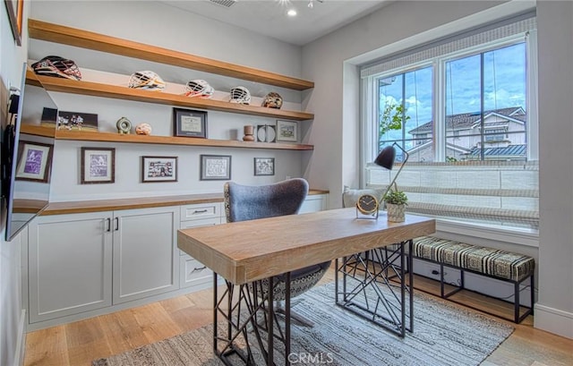 home office with light hardwood / wood-style floors