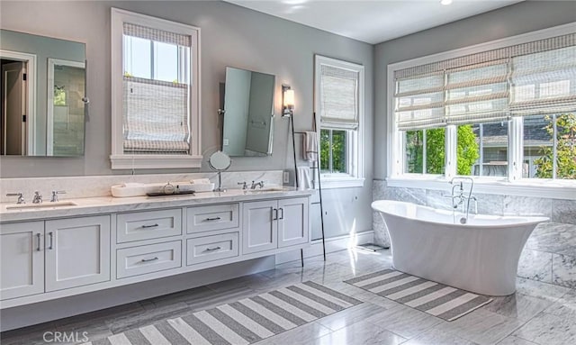 bathroom featuring tile patterned flooring, a bath, and vanity