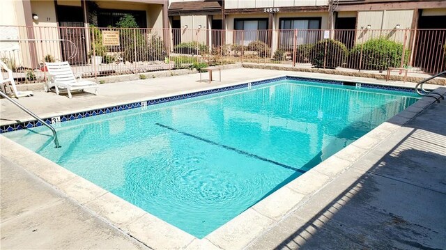 pool featuring fence and a patio area