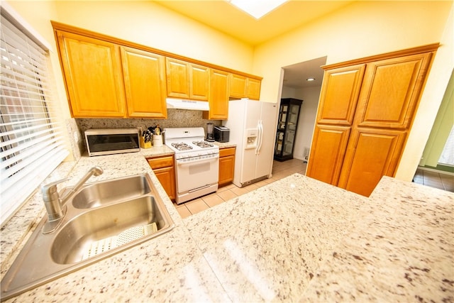 kitchen featuring white appliances, light tile patterned floors, and sink