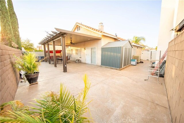 view of patio / terrace with a pergola and a storage unit