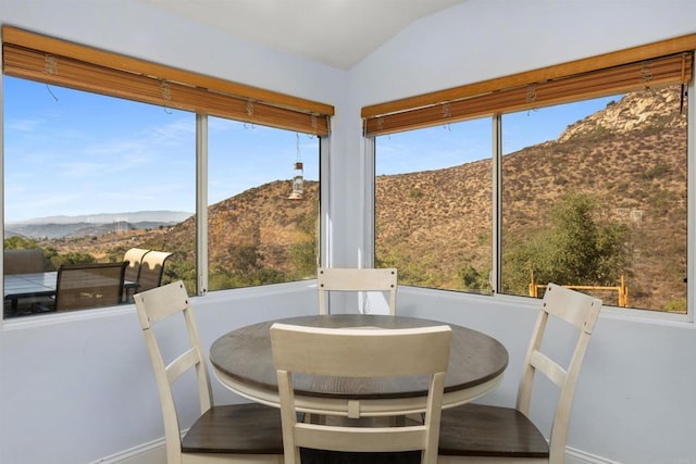 sunroom featuring lofted ceiling, a healthy amount of sunlight, and a mountain view