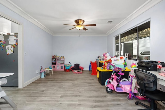 playroom with ornamental molding, ceiling fan, and light wood-type flooring