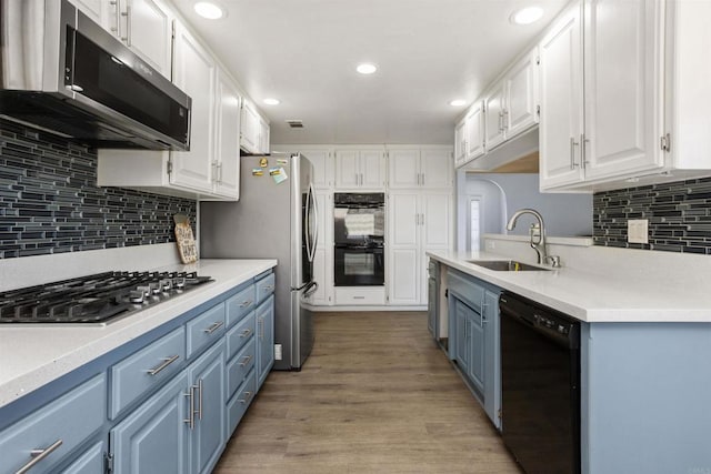 kitchen featuring white cabinets, blue cabinets, sink, and black appliances