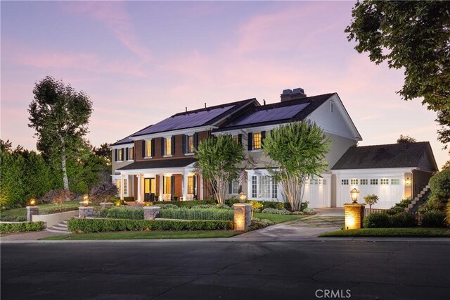 view of front of property with solar panels and a garage