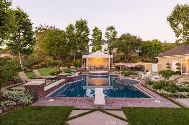 view of pool with an in ground hot tub, a diving board, and a patio area