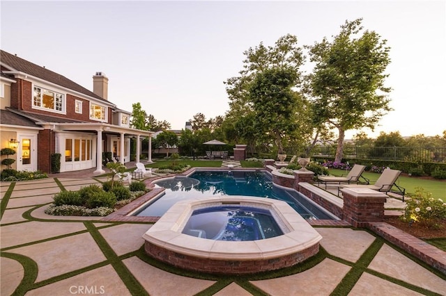 view of swimming pool featuring an in ground hot tub and a patio