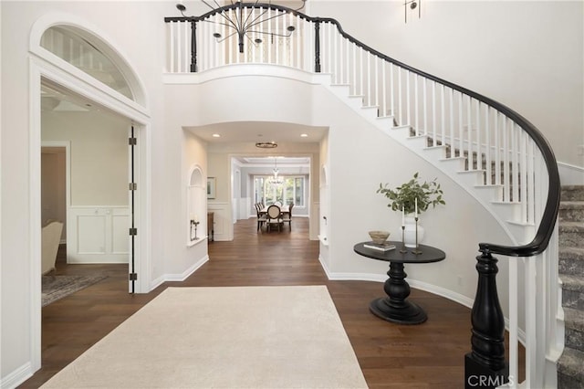 entrance foyer featuring a high ceiling, dark hardwood / wood-style floors, and a notable chandelier