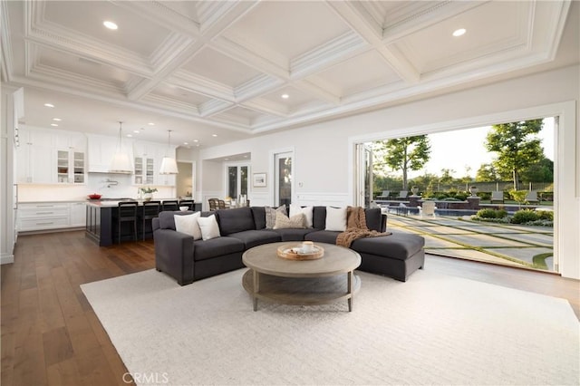 living room with beam ceiling, dark hardwood / wood-style flooring, crown molding, and coffered ceiling