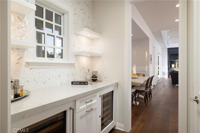 bar featuring light stone countertops, wine cooler, tasteful backsplash, dark hardwood / wood-style floors, and white cabinetry