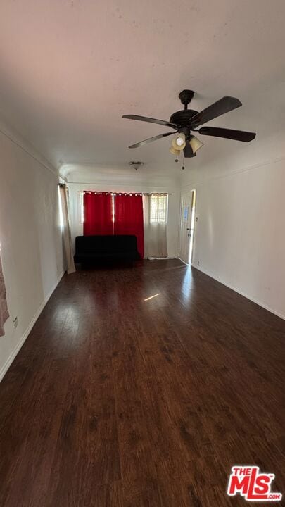 unfurnished living room with ceiling fan and dark hardwood / wood-style flooring