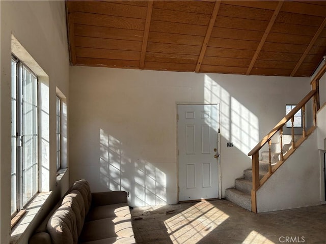 foyer entrance with beamed ceiling, high vaulted ceiling, and wood ceiling