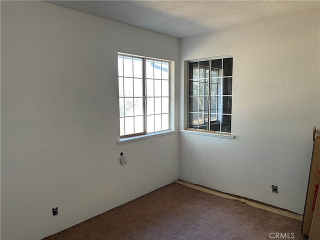 carpeted spare room featuring a textured ceiling